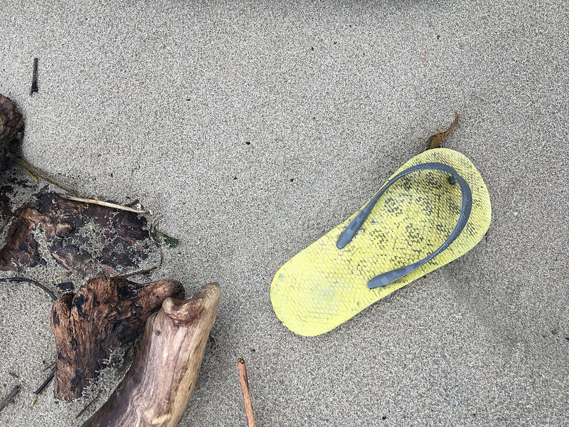 Yellow flip flop on beach sand
