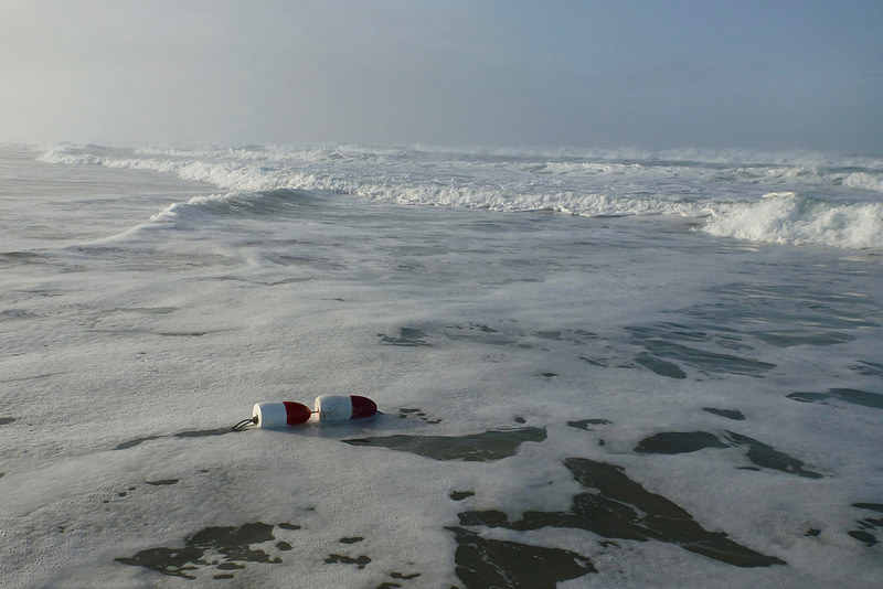 Red and white floats identify lost crab gear drifted into the surf zone