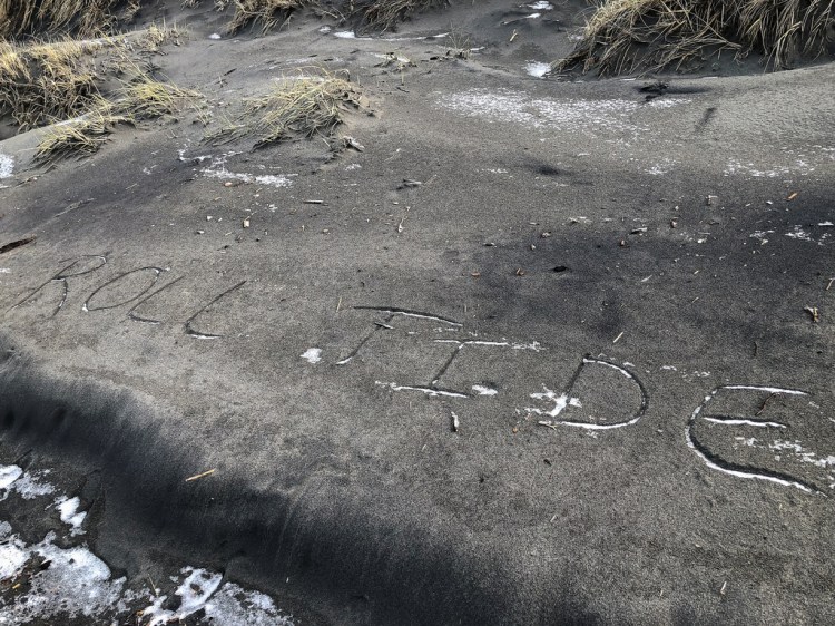 Someone wrote Roll Tide in the sand at the base of the foredune