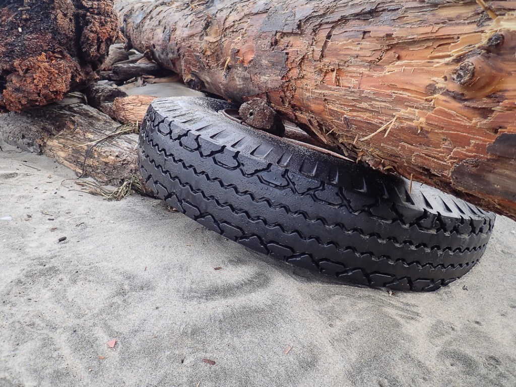 Tire trapped under a large drift log
