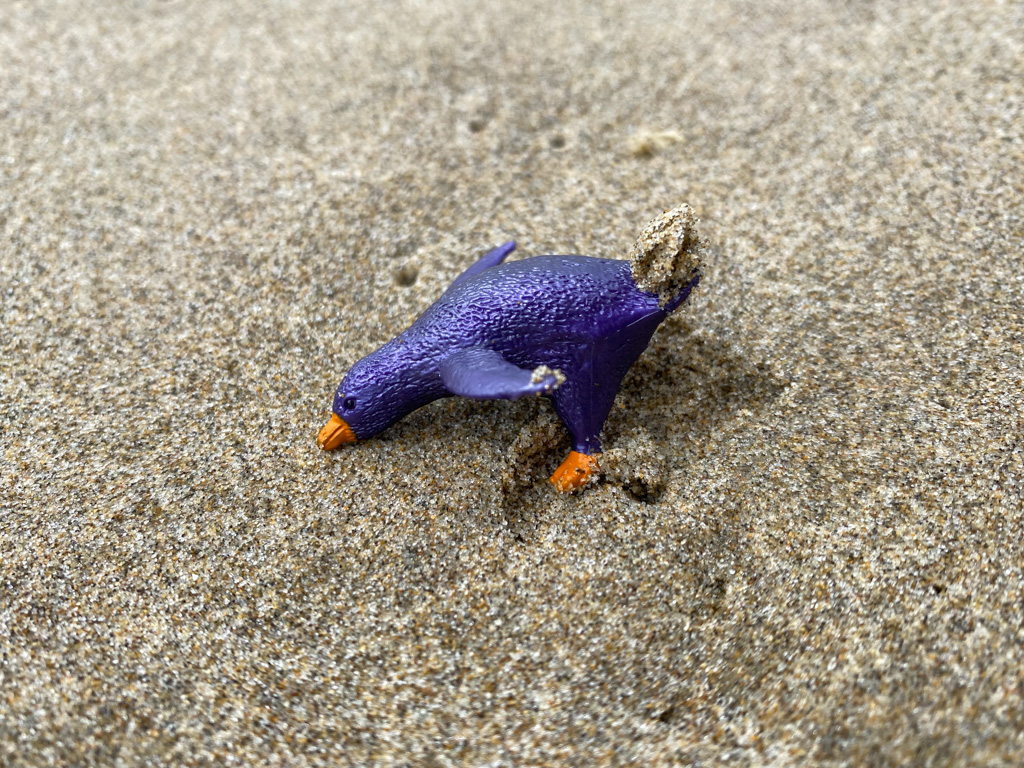 A small royal indigo-colored penguin-like plastic toy
