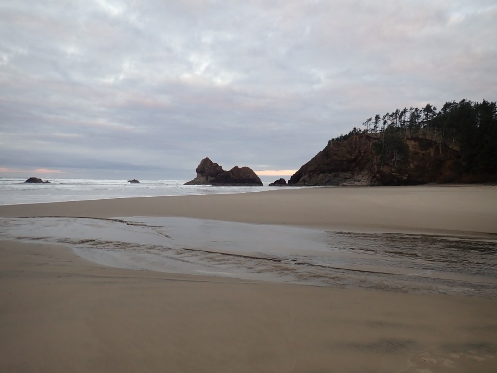 Moody seascape with a massive rock in the distance. Its profile resembles a resting lion. Mostly cloudy skies.