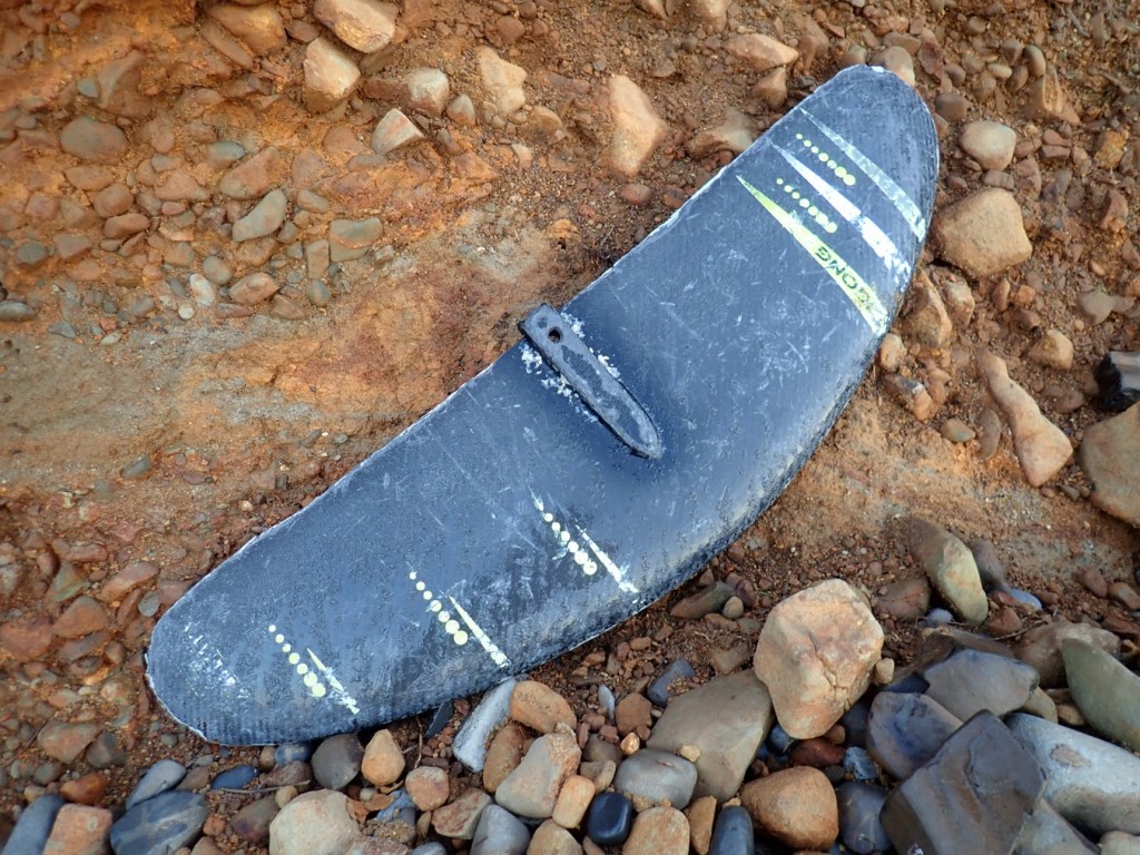 A lost front wing rests at the top of the cobbles.