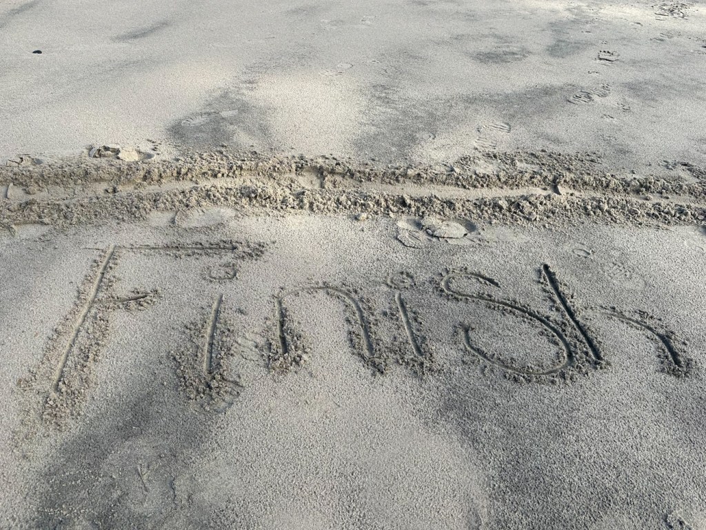 A line and the word "Finish" scraped into the sand.