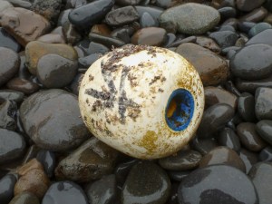 Closeup of a styrofoam float with Chinese characters resting on the cobbles.