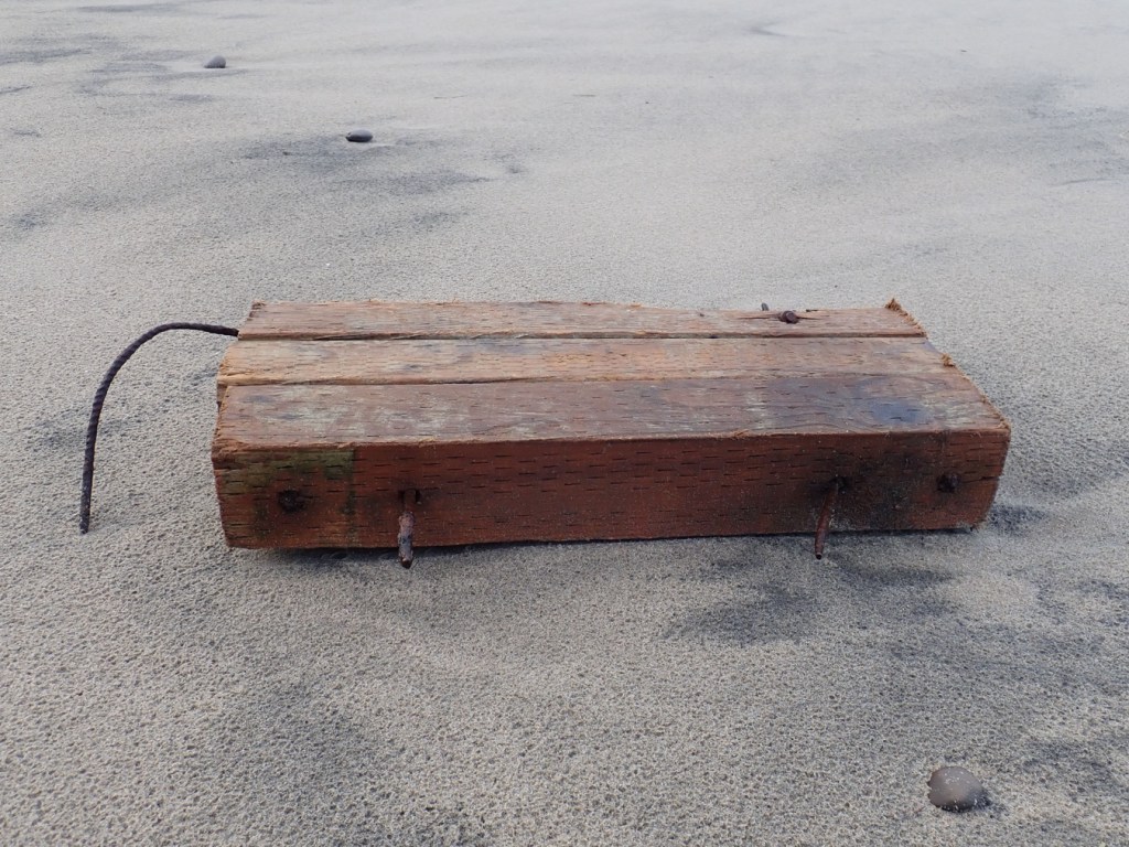 Treated wood held together with rebar resting on the sand.