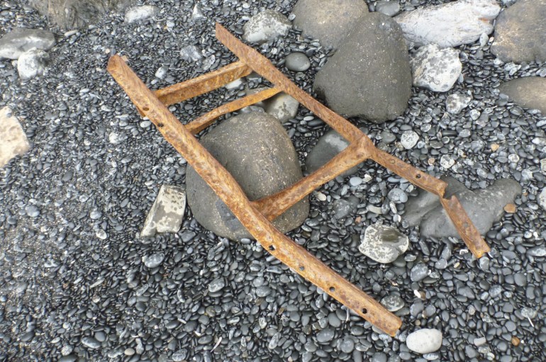 Remains of a wrecked metal ladder rest in the cobbles.