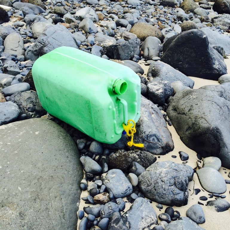 A lost and drifted DIY buoy rests on the cobbles.