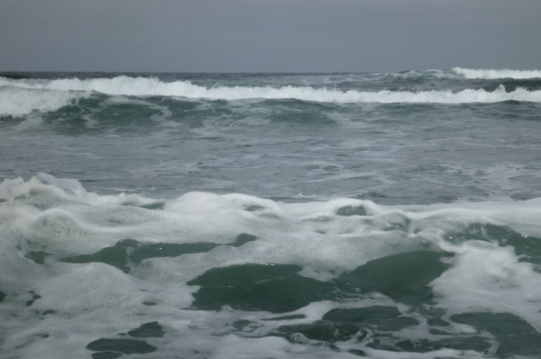 View of the surf zone from in it. Cloudy sky.